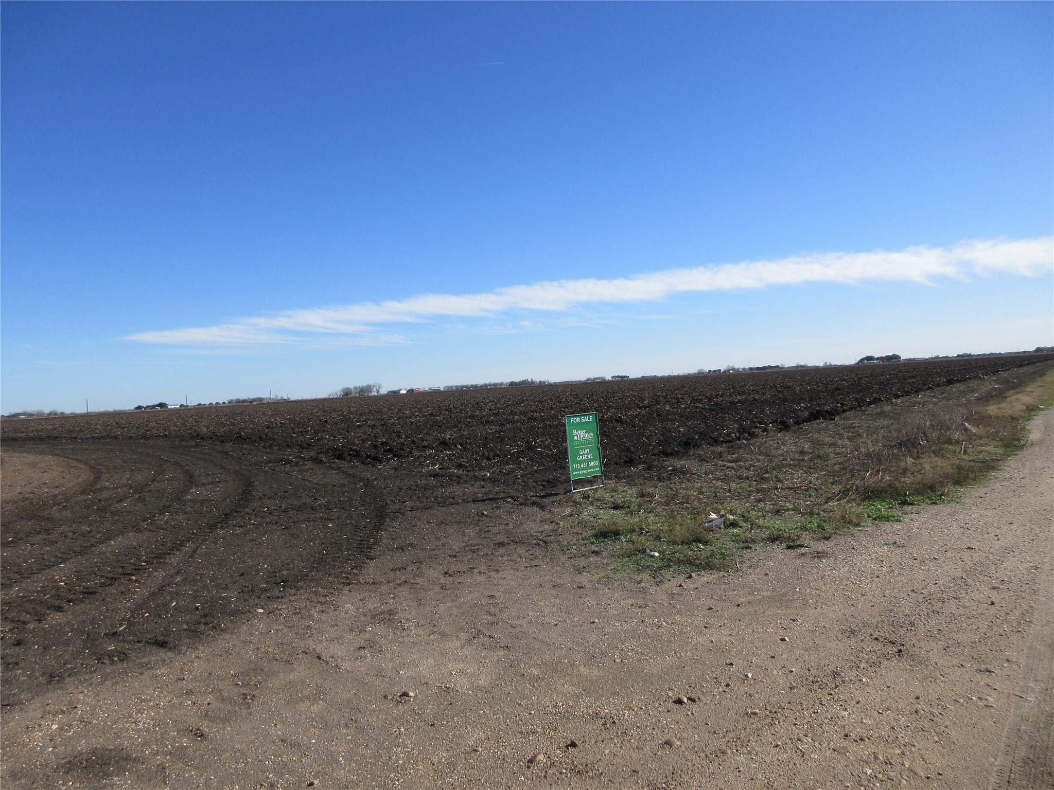 a view of a dry field with mountains in the background