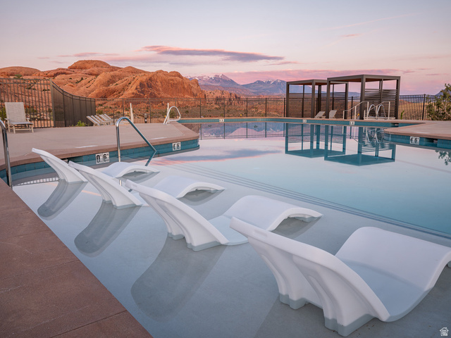 213 Lionsback Loop, Unit 38 Moab, UT 84532 - Photo 22 of 26 Resort-style pool featuring submerged lounge seating, dual pergolas, and a surrounding deck