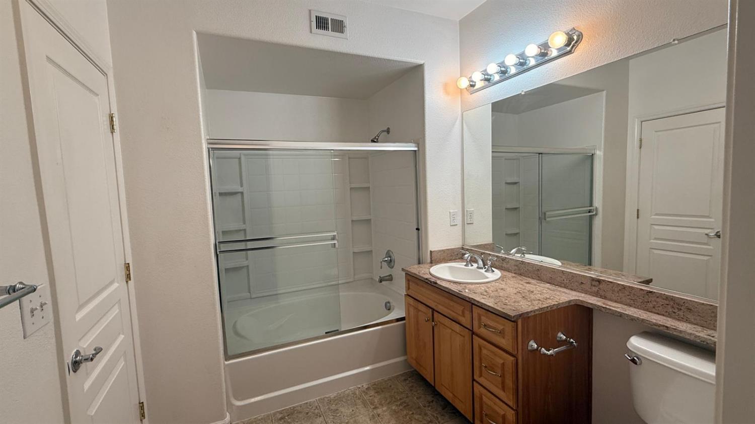 1360 Shady Lane, Unit 923 Turlock, CA 95382 - Photo 11 of 13 a bathroom with a granite countertop sink and a mirror