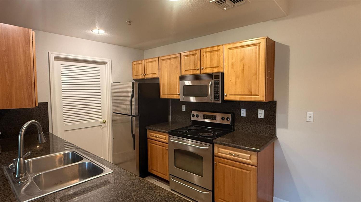 1360 Shady Lane, Unit 923 Turlock, CA 95382 - Photo 7 of 13 a kitchen that has a sink and a stove top oven