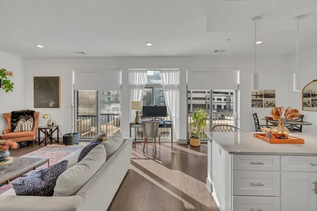 a living room with furniture large window and flat screen tv
