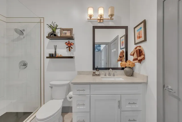 a bathroom with a sink vanity mirror and toilet