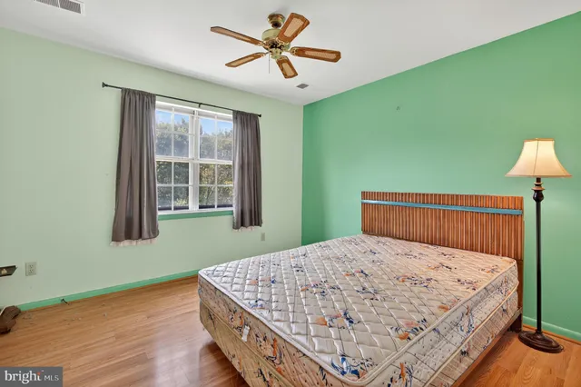 a bed sitting in a bedroom next to a window