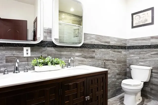 a bathroom with a sink a toilet and mirror