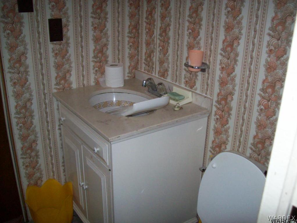 3564 Emery Park Road Golden Valley, AZ 86413 - Photo 8 of 9 a bathroom with a granite countertop sink and a toilet