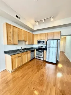 a kitchen with granite countertop a stove a sink and a refrigerator