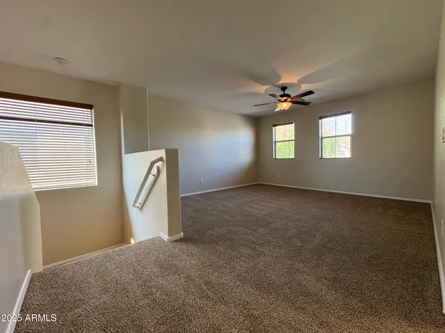 a view of a livingroom with a ceiling fan and window