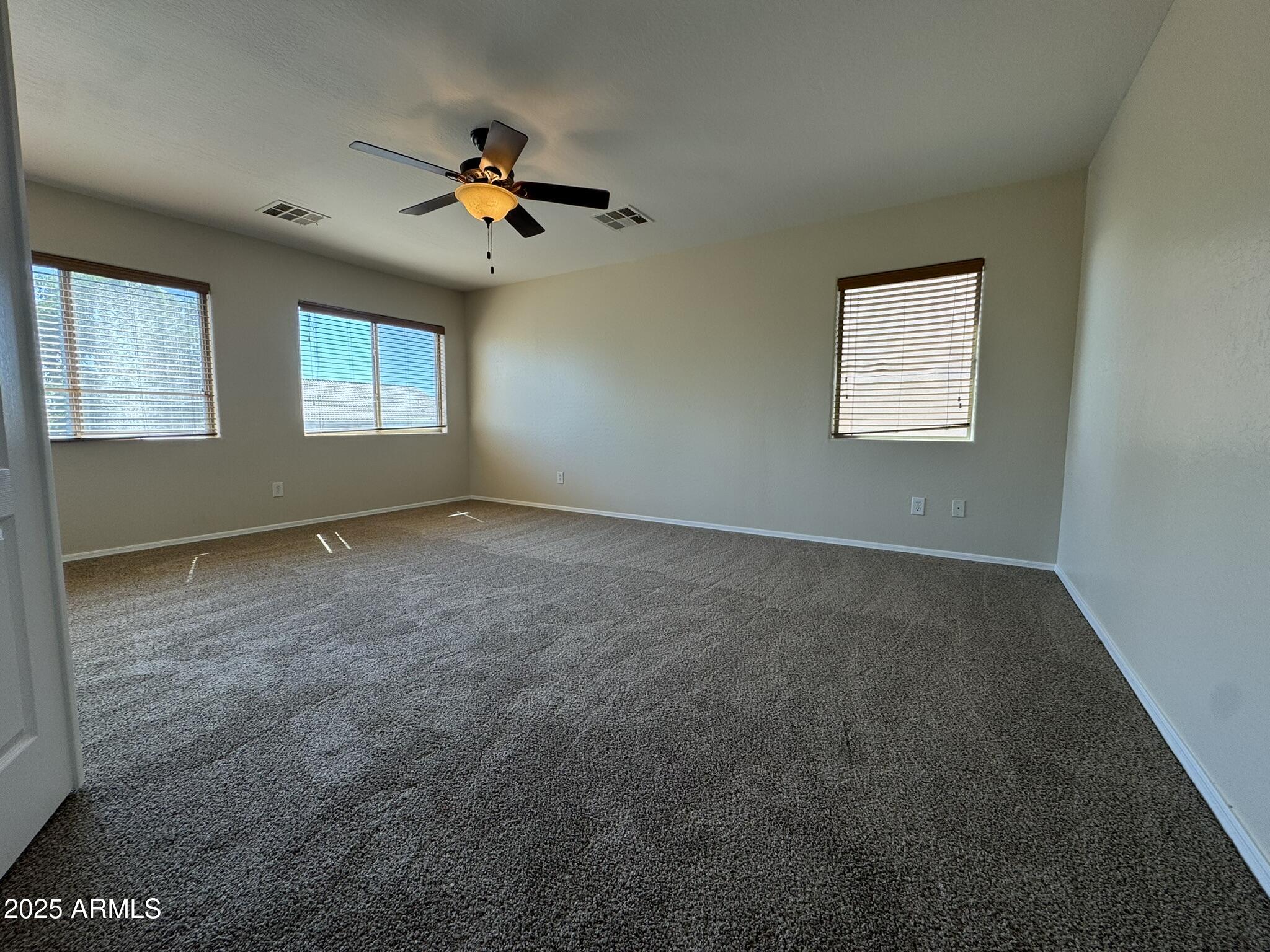 2311 West Hunter Court Phoenix, AZ 85085 - Photo 18 of 24 an empty room with windows and fan
