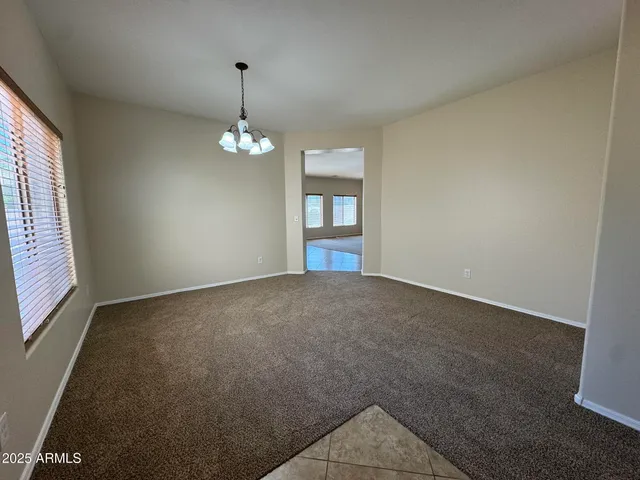 an empty room with windows and ceiling fan
