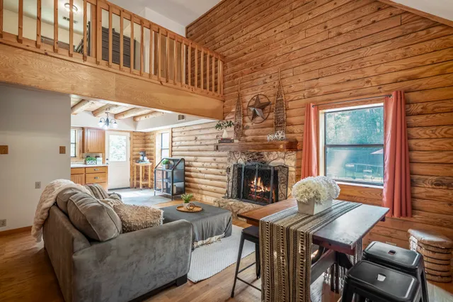 a living room with furniture a fireplace and a table