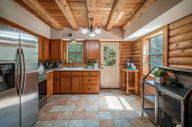 a kitchen with stainless steel appliances granite countertop a stove a refrigerator a sink and dishwasher