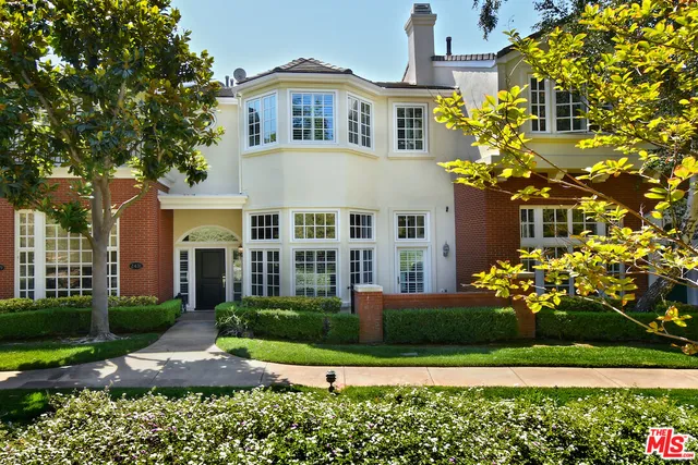 a front view of a house with a yard and fountain