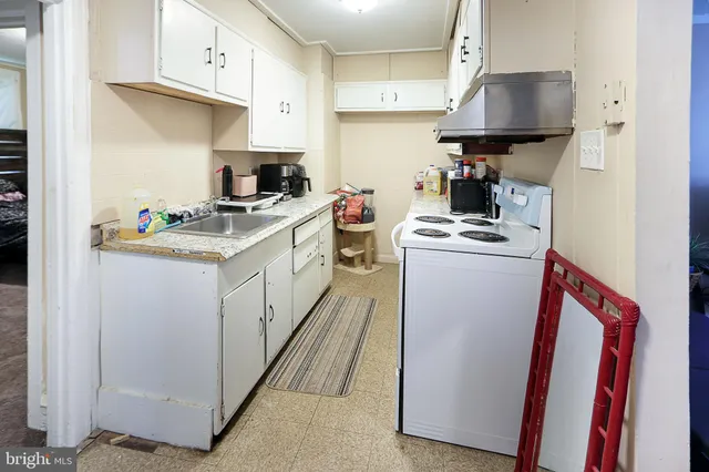 a kitchen with a sink a stove and cabinets
