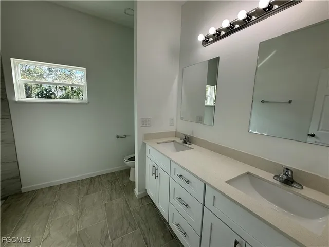 a bathroom with a double vanity sink and a mirror