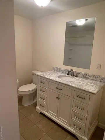 a bathroom with a granite countertop toilet and a sink