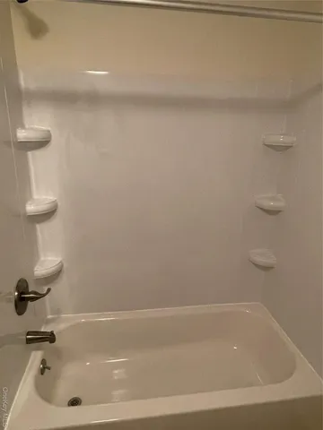 a bathroom with a white bath tub and a sink