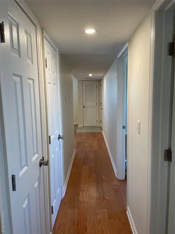 a view of a hallway with wooden floor