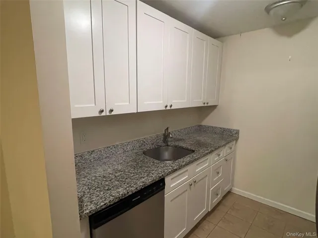a kitchen with granite countertop a sink and cabinets