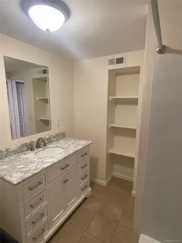 a bathroom with a granite countertop sink and a mirror