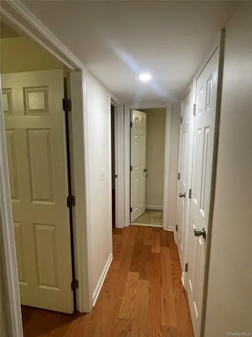 a view of a hallway with wooden floor and closet area