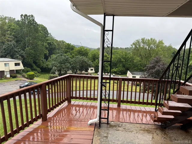a view of balcony with wooden floor and fence