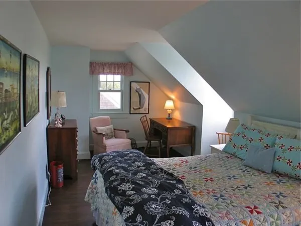 a bedroom with a bed and a dresser next to a window