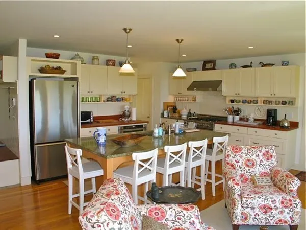 a kitchen with stainless steel appliances kitchen island granite countertop a refrigerator and microwave