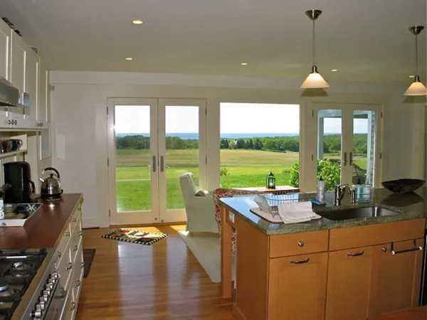 a kitchen with a large window and dining table