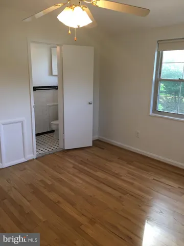 an empty room with wooden floor and mirror
