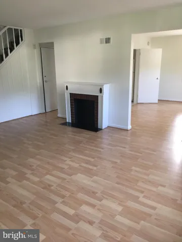 a view of empty room with wooden floor and fireplace