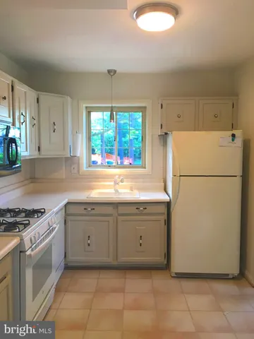 a kitchen with granite countertop a sink a counter space and cabinets