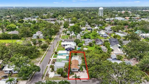 an aerial view of residential houses with outdoor space and trees
