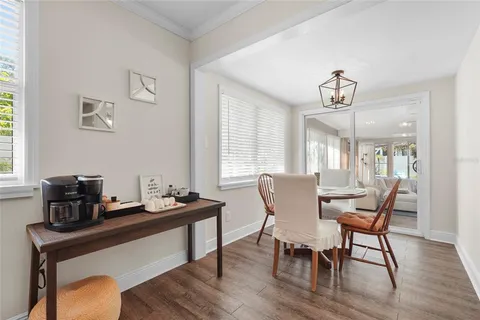 a view of a patio with table and chairs potted plants and large tree