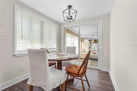 a view of a patio with table and chairs and potted plants with large tree
