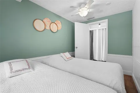 a view of a patio with table and chairs and potted plants with large tree