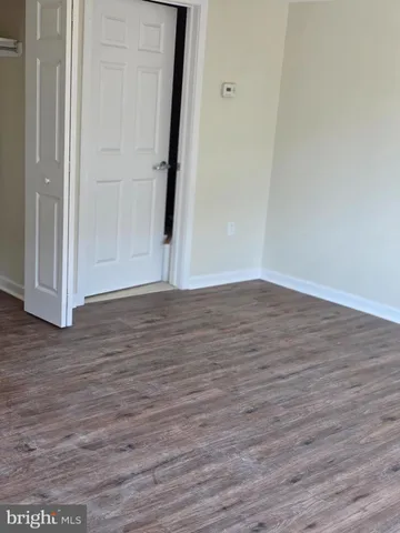 an empty room with wooden floor and closet