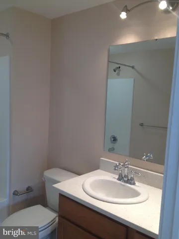 a bathroom with a sink a toilet and mirror