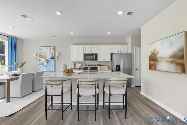 a kitchen with white cabinets and stainless steel appliances