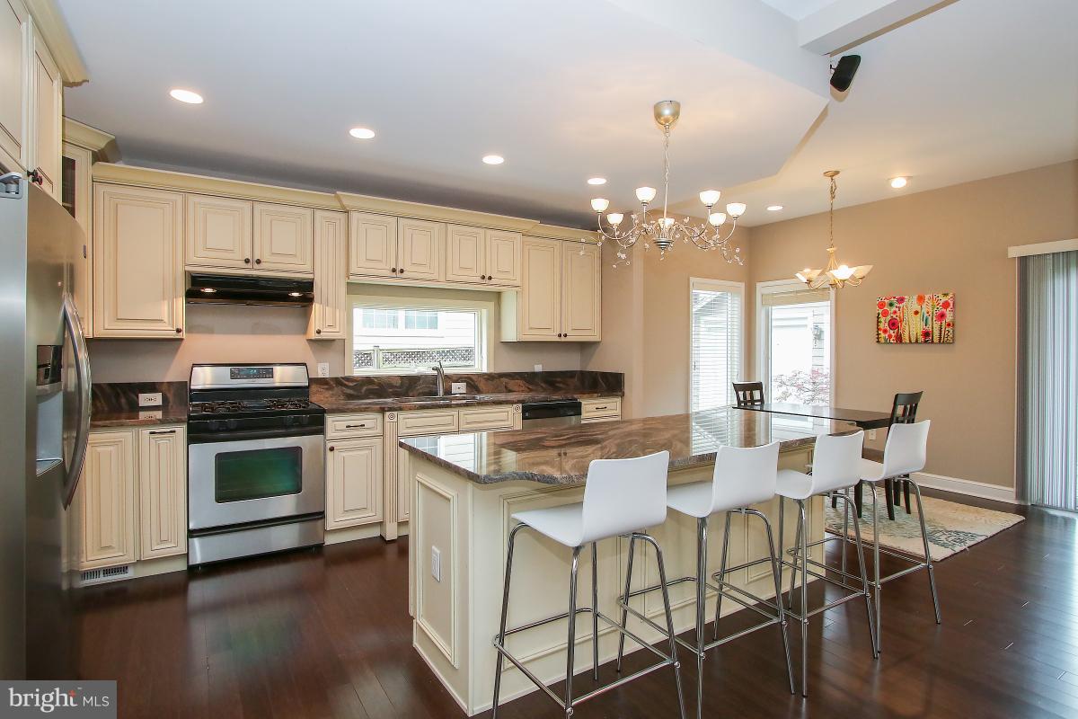 5612 Greentree Road Bethesda, MD 20817 - Photo 15 of 28 a kitchen with a dining table chairs stainless steel appliances and cabinets