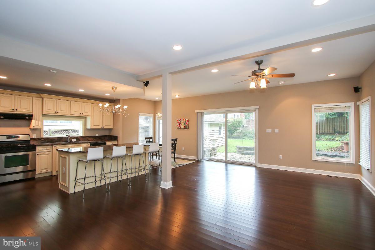 5612 Greentree Road Bethesda, MD 20817 - Photo 8 of 28 a living room with stainless steel appliances kitchen island granite countertop a stove top oven a dining table and chairs with wooden floor