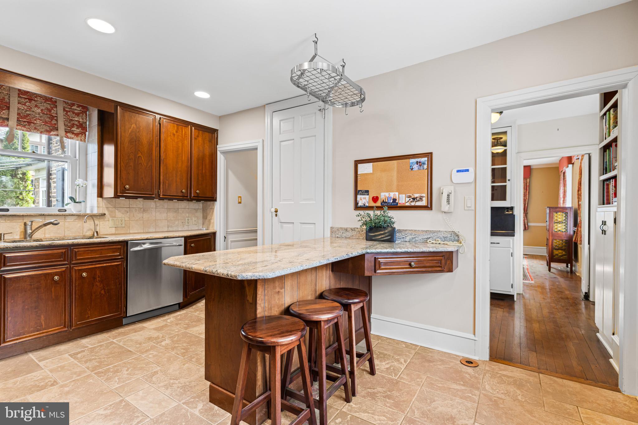 764 Glen Road Jenkintown, PA 19046 - Photo 16 of 57 a kitchen with stainless steel appliances kitchen island a table chairs in it and wooden floors