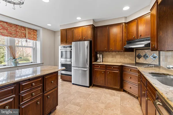 a kitchen with granite countertop stainless steel appliances and wooden cabinets