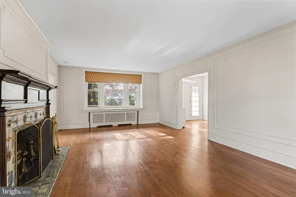 a view of empty room with fireplace and wooden floor