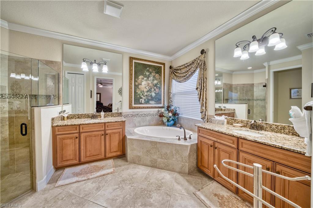9446 Piacere Way Naples, FL 34113 - Photo 17 of 23 a large bathroom with a sink a large mirror and a bathtub