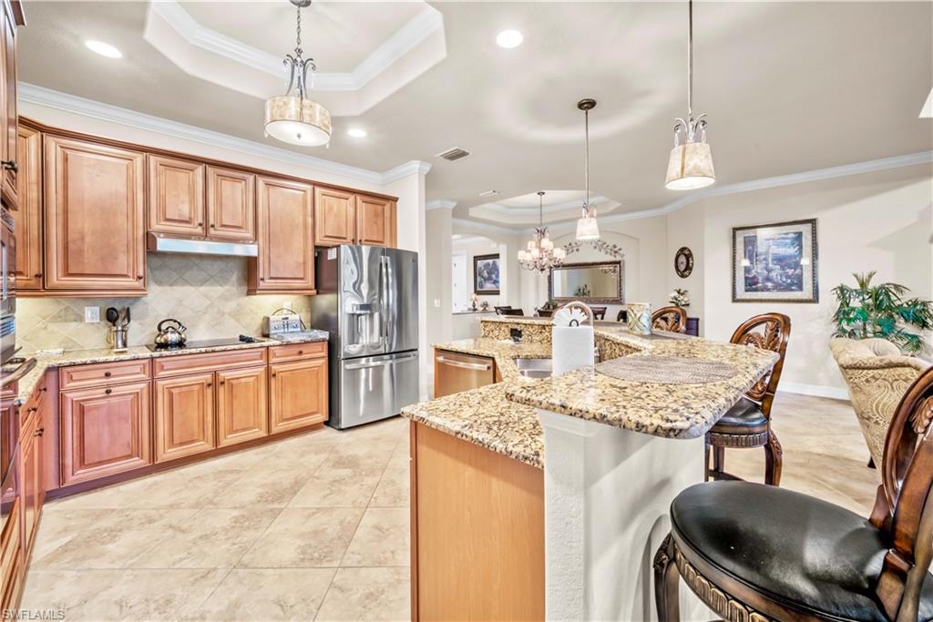 9446 Piacere Way Naples, FL 34113 - Photo 7 of 23 a large kitchen with kitchen island a large counter top space appliances and cabinets