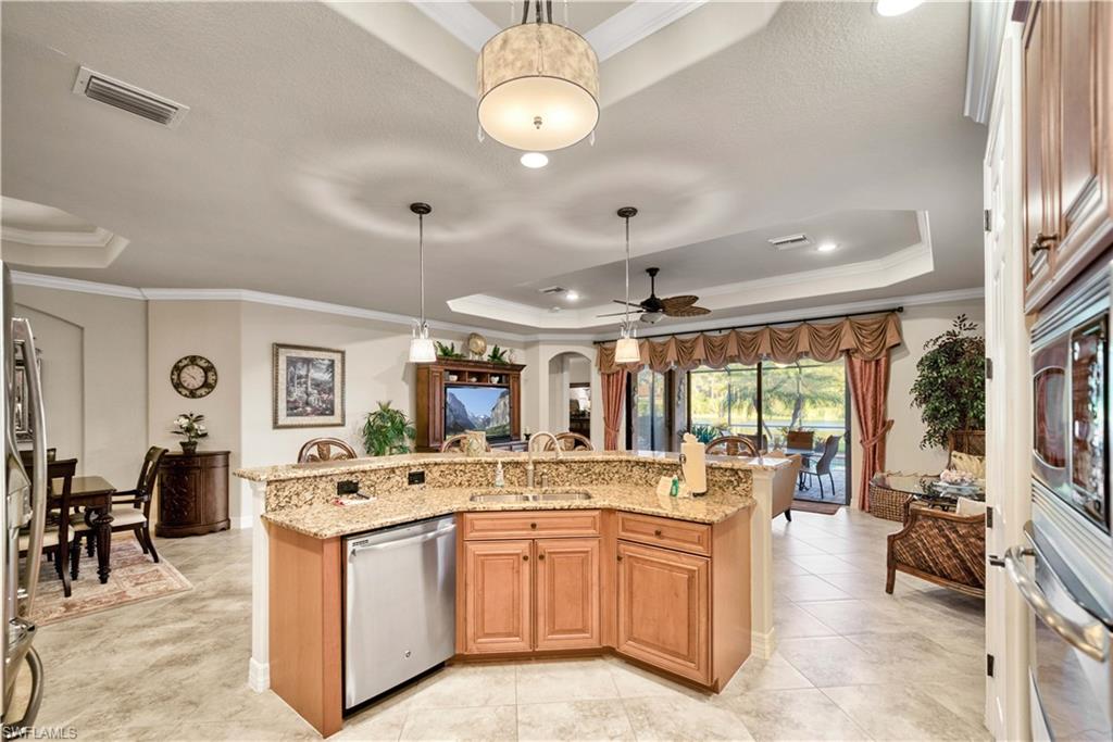 9446 Piacere Way Naples, FL 34113 - Photo 8 of 23 a large kitchen with kitchen island a large counter space dining table and stainless steel appliances