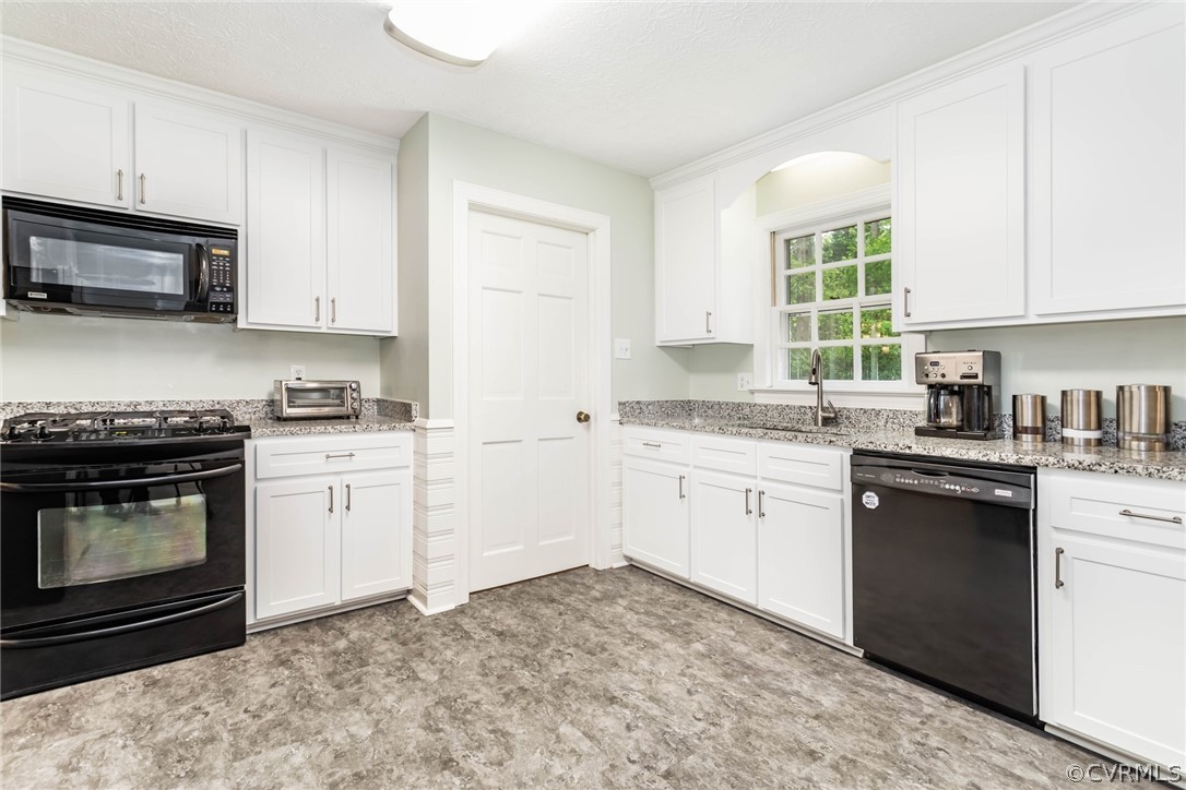 6 Staples Road Williamsburg, VA 23185 - Photo 13 of 37 a kitchen with granite countertop a stove top oven sink and cabinets