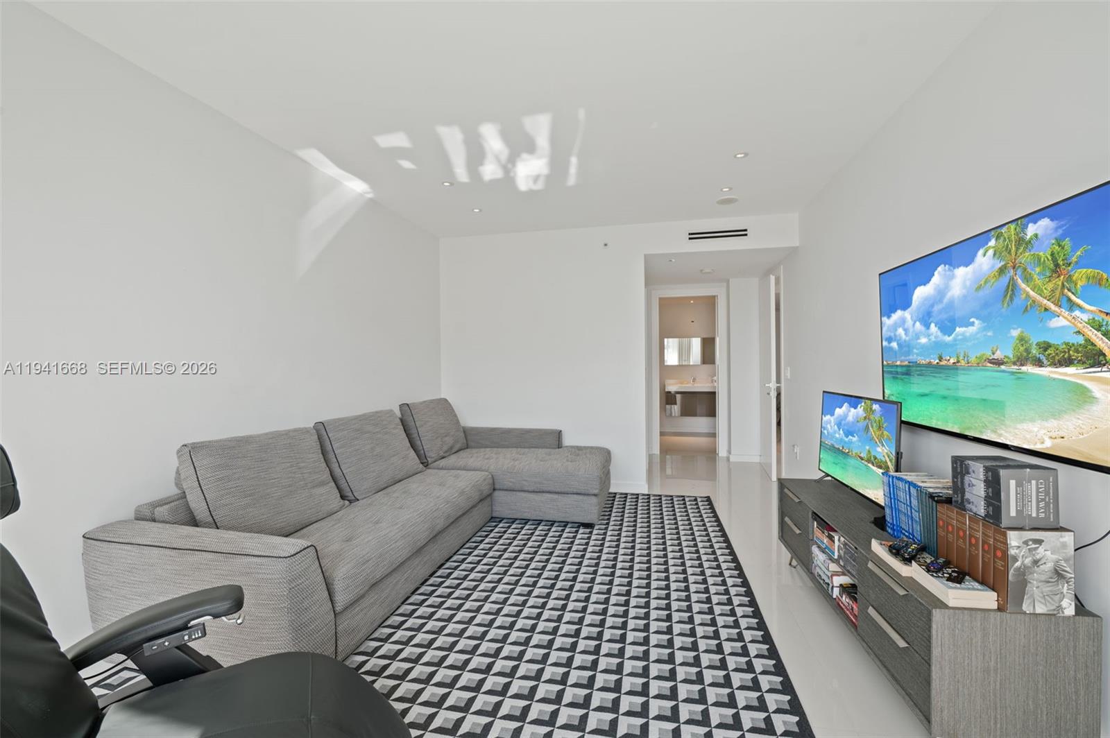 9601 Collins Avenue, Unit 908 Bal Harbour, FL 33154 - Photo 15 of 29 a living room with furniture and a flat screen tv