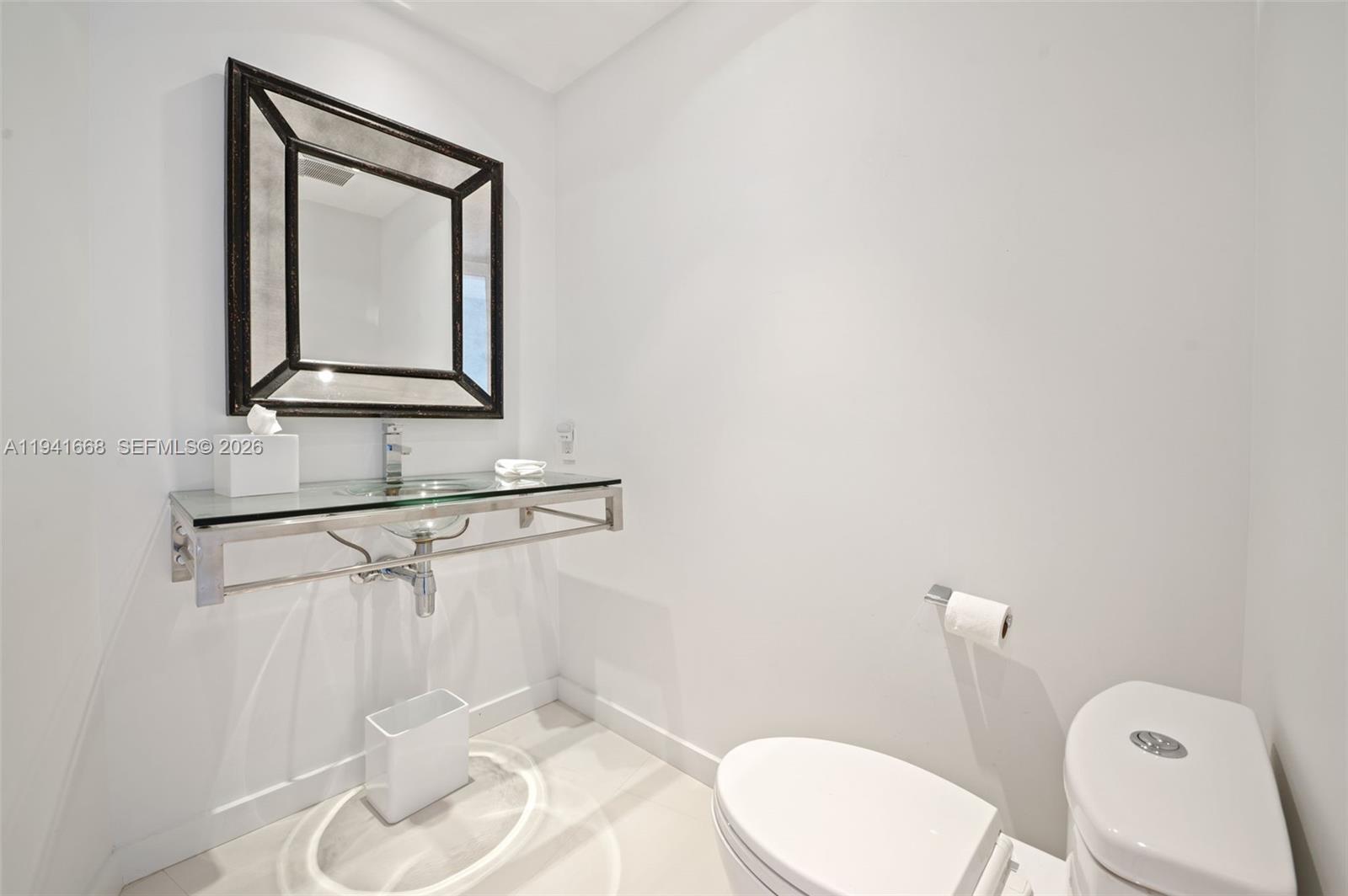 9601 Collins Avenue, Unit 908 Bal Harbour, FL 33154 - Photo 22 of 29 a bathroom with a toilet a sink and mirror