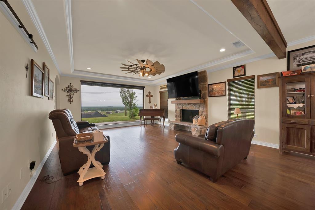 100 Shadle Ridge Court Poolville, TX 76487 - Photo 5 of 40 Expansive living area featuring wide plank wood-finish flooring and a stone-clad fireplace